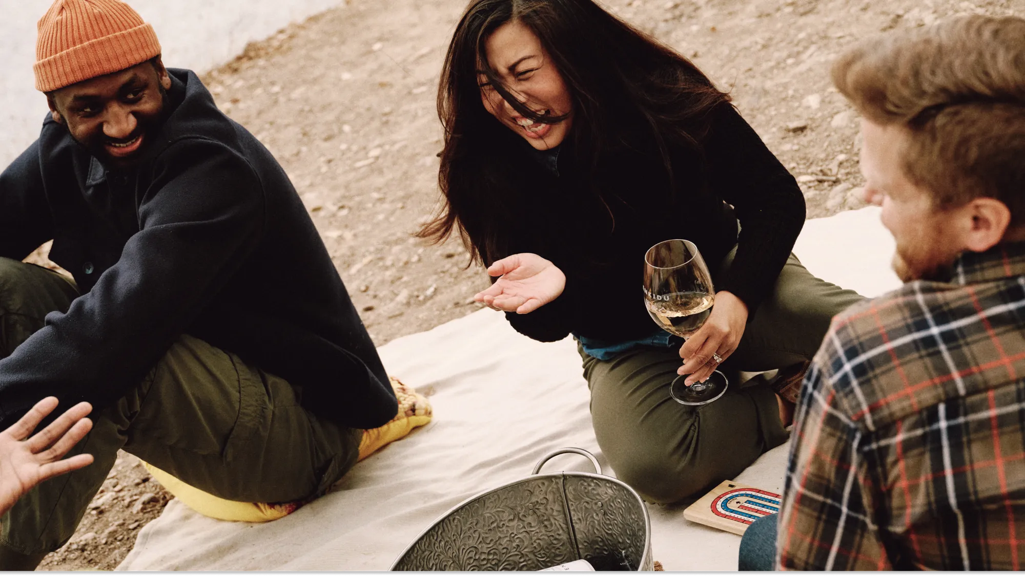 Friends laughing together and drinking wine