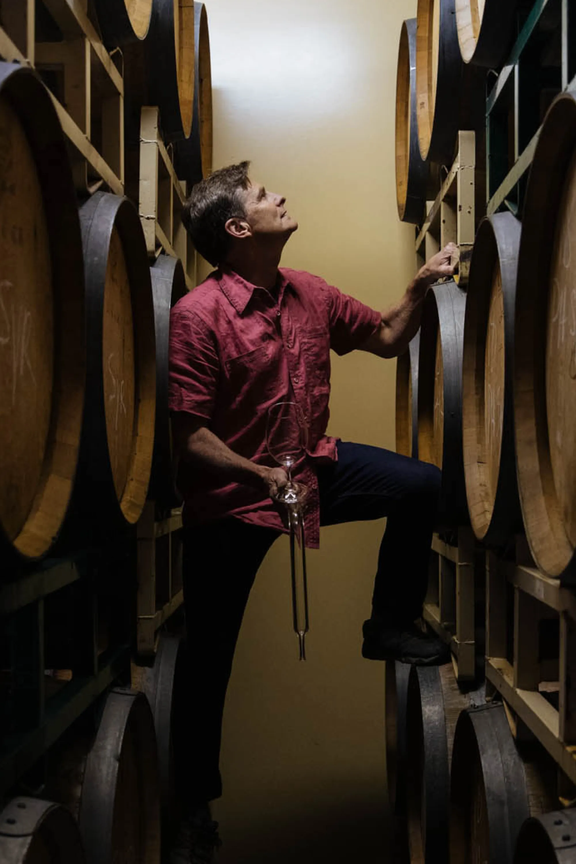 Chuck Reininger posing with wine barrels. 