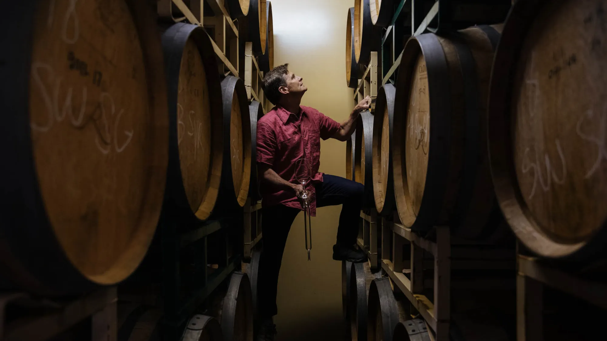 Chuck Reininger posing with wine barrels. 