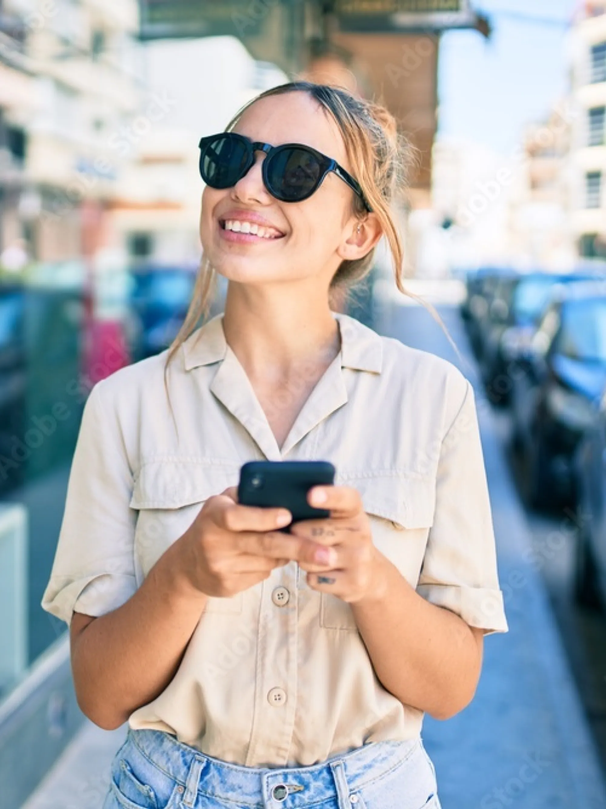 Woman wearing sunglasses holding cell phone